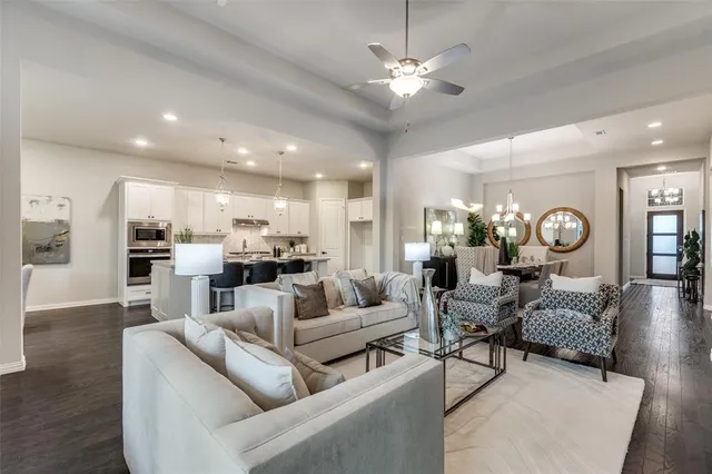 a living room with furniture kitchen view and a chandelier