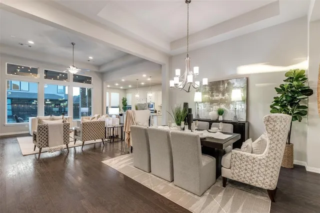 a living room with furniture a chandelier and a dining table with wooden floor