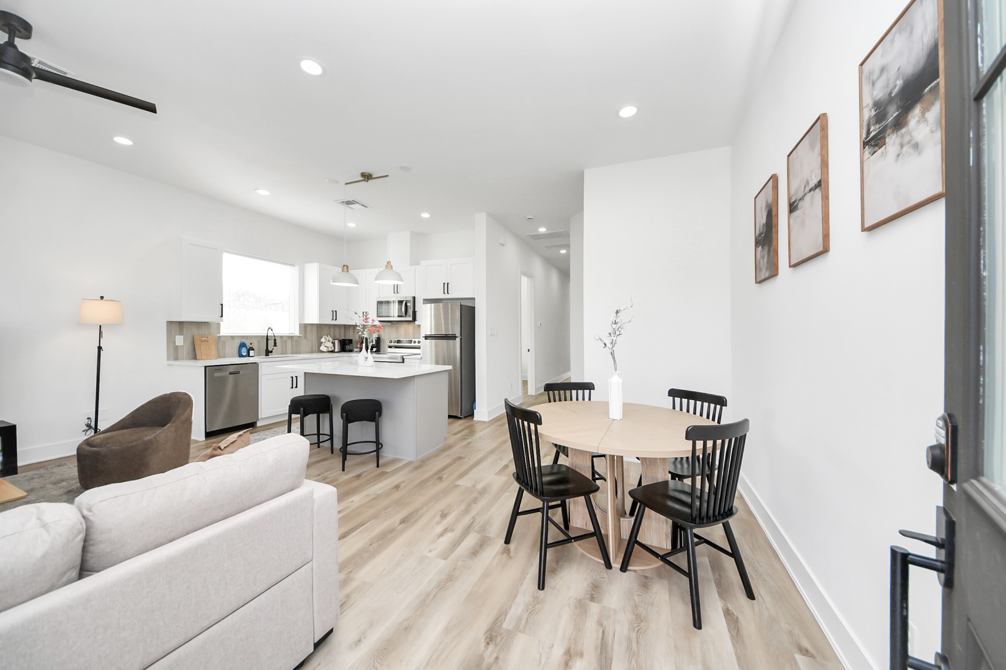 a living room with stainless steel appliances kitchen island a table and chairs in it