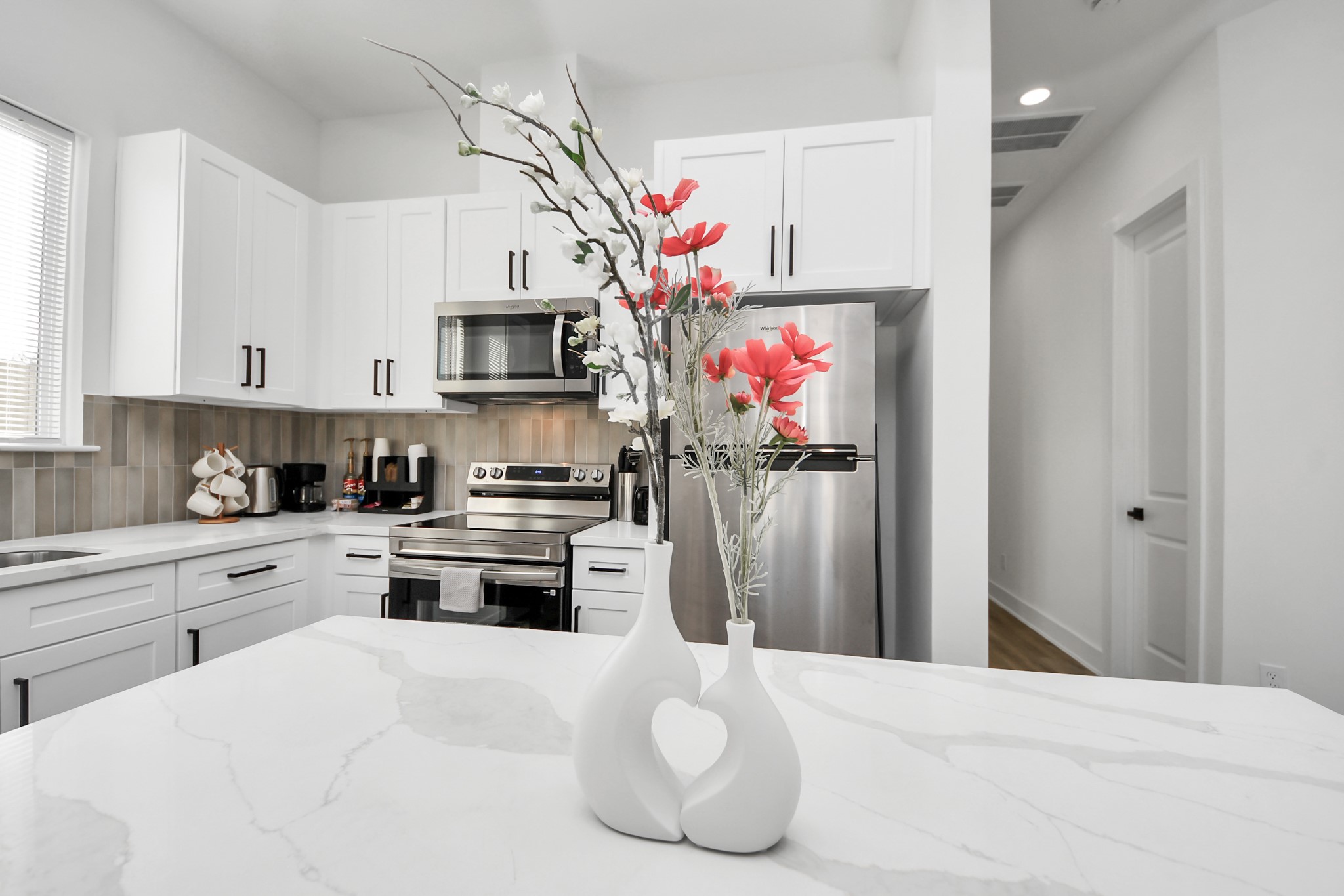 3909 Maggie Street Houston, TX 77051 - Photo 12 of 49 a kitchen that has a lot of white cabinets and stainless steel appliances