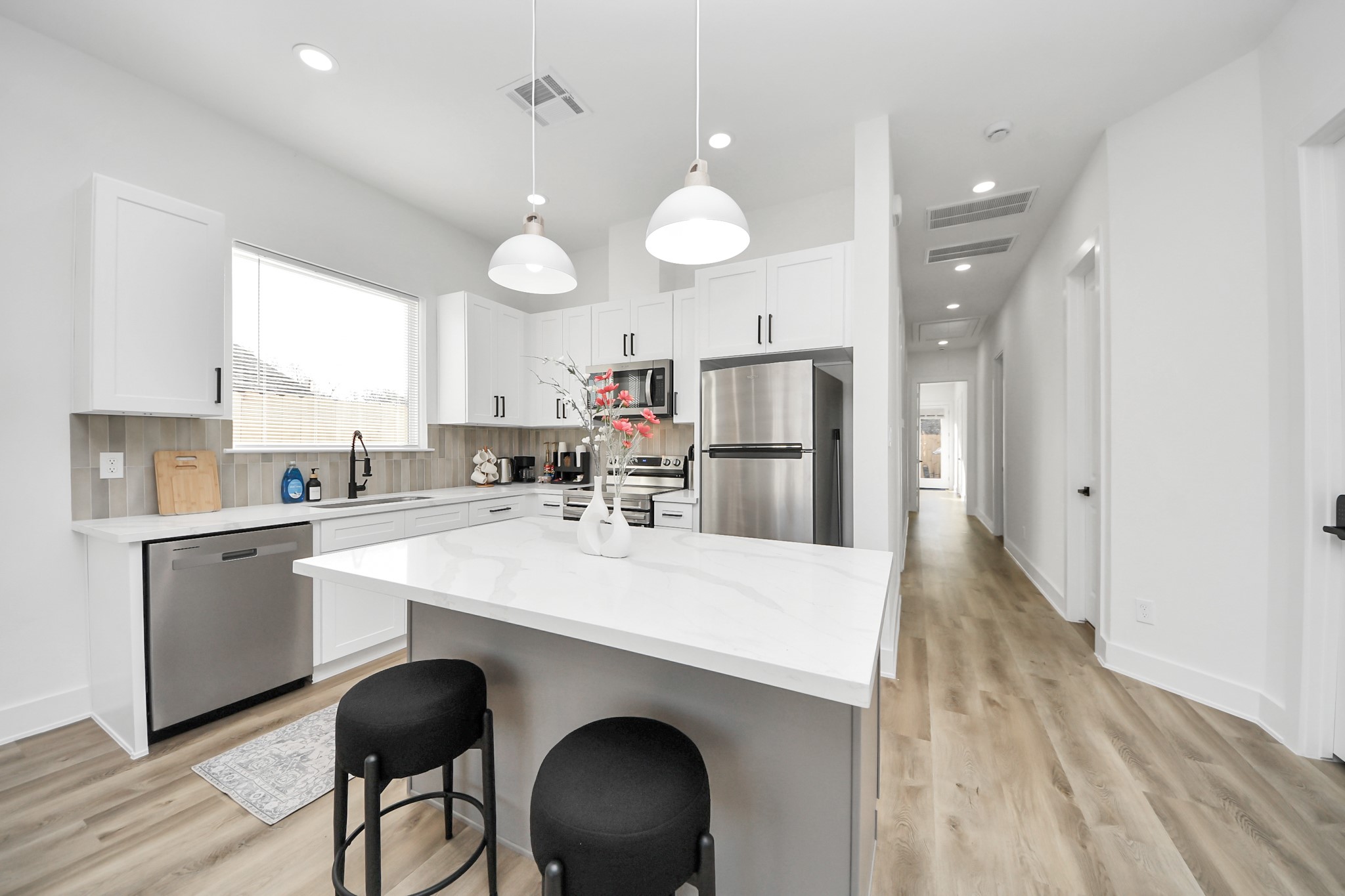 3909 Maggie Street Houston, TX 77051 - Photo 13 of 49 a kitchen with stainless steel appliances a refrigerator a sink a stove a dining table and chairs with wooden floor