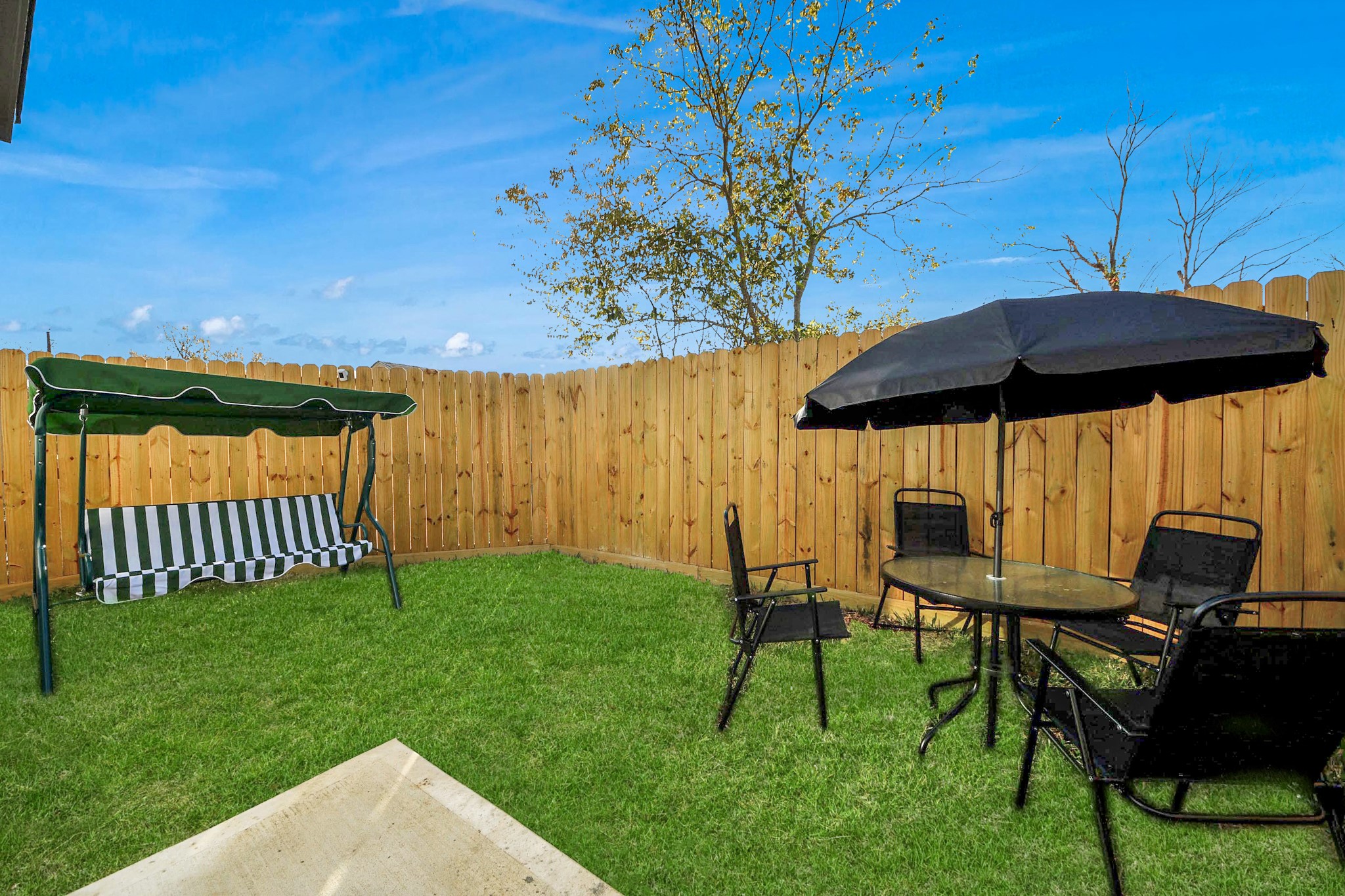 3909 Maggie Street Houston, TX 77051 - Photo 48 of 49 a view of a patio with table and chairs under an umbrella with a small yard