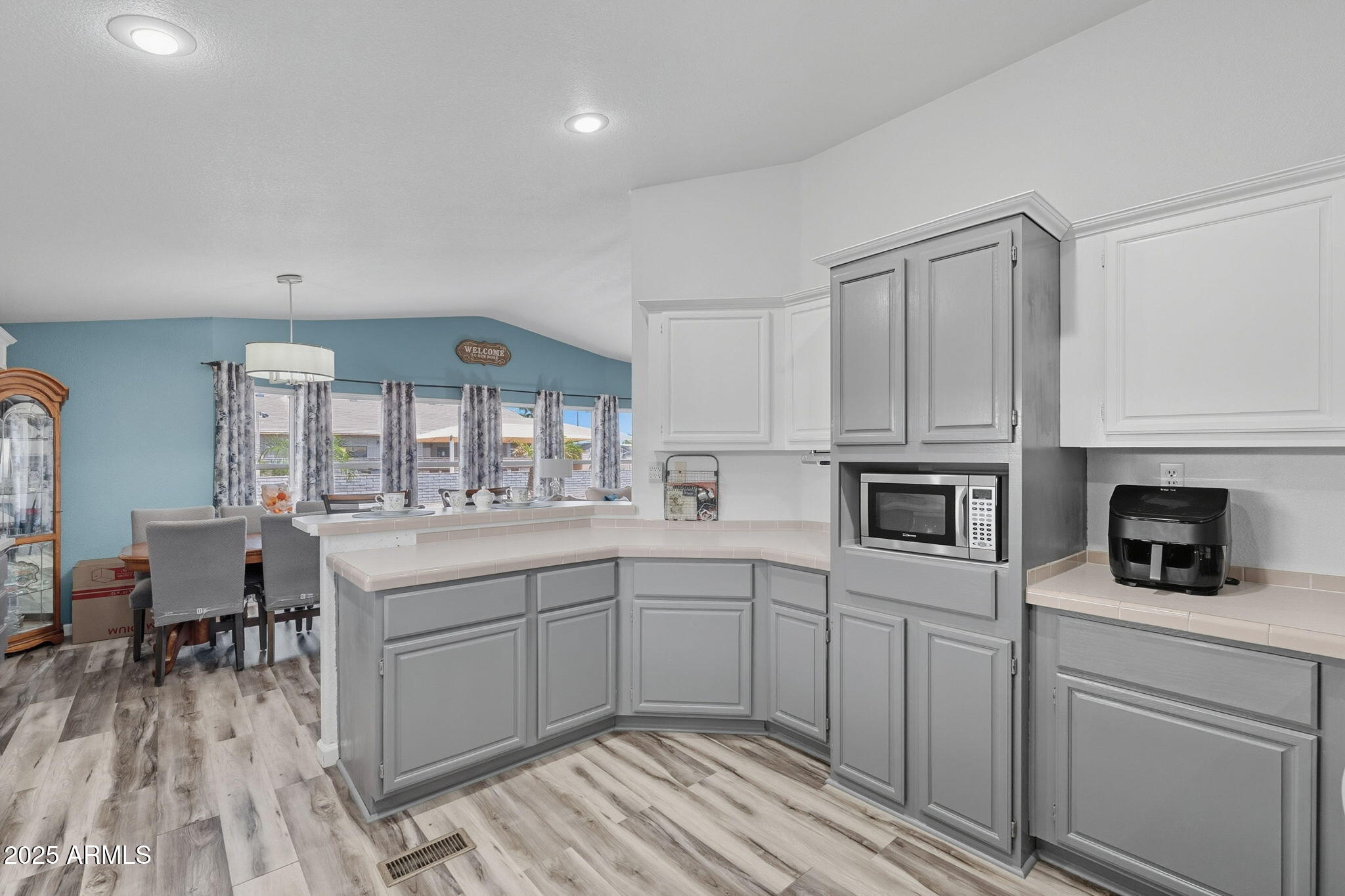 3700 South Tomahawk Road, Unit 39 Apache Junction, AZ 85119 - Photo 2 of 53 a kitchen with white cabinets a sink and dishwasher with wooden floor