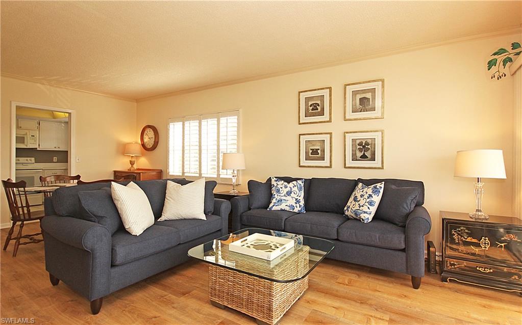 666 3rd Street South, Unit 201 Naples, FL 34102 - Photo 4 of 19 a living room with furniture and a wooden floor