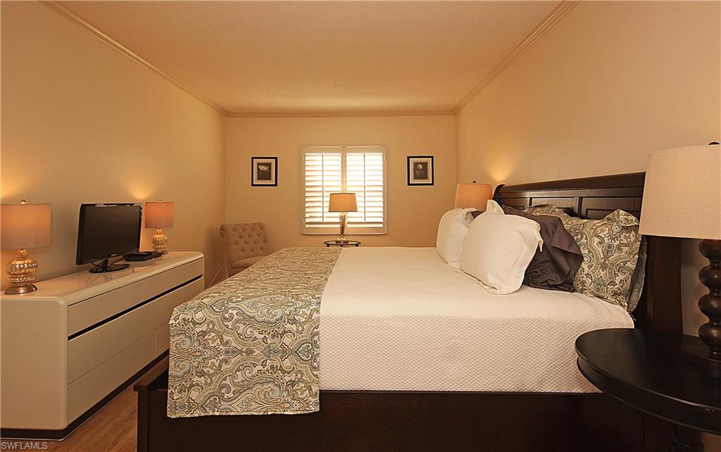 666 3rd Street South, Unit 201 Naples, FL 34102 - Photo 6 of 19 a bedroom with a bed and wooden floor