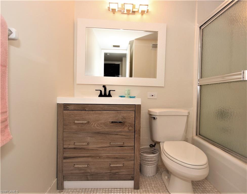 666 3rd Street South, Unit 201 Naples, FL 34102 - Photo 10 of 19 a bathroom with a toilet sink and mirror