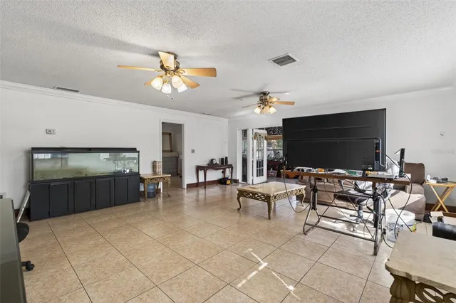a living room with furniture a flat screen tv and kitchen view
