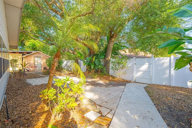 a view of a chair and table in backyard of the house