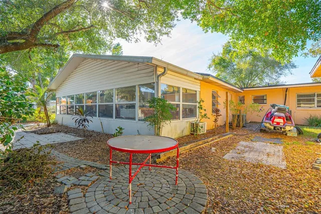 a front view of a house with garden and trees