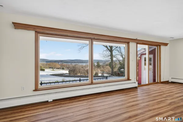 a view of a room with wooden floor and a floor to ceiling window