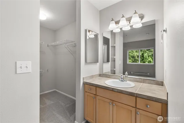 a bathroom with a granite countertop sink and a mirror