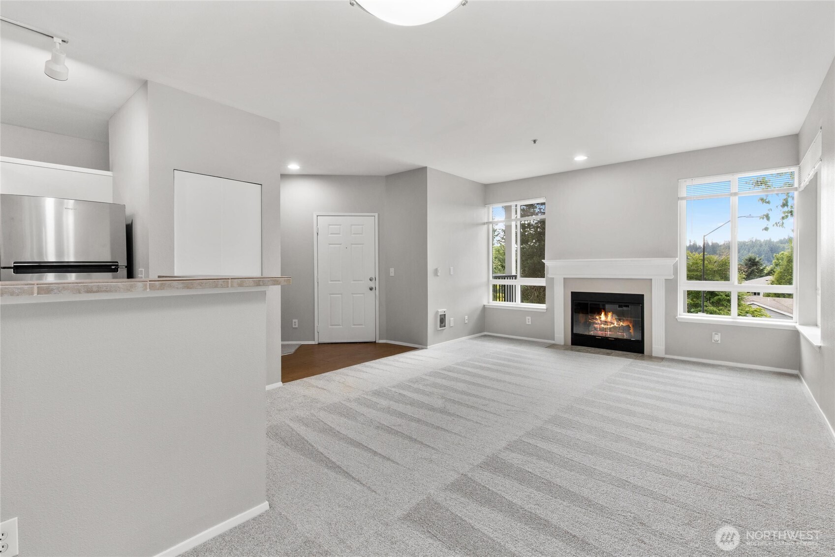 3926 243rd Place Southeast, Unit H201 Bothell, WA 98021 - Photo 5 of 31 a view of a livingroom with a fireplace a ceiling fan and windows