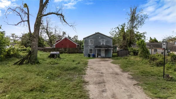 a front view of a house with a yard and trees