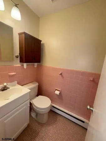 a bathroom with a toilet a sink and mirror