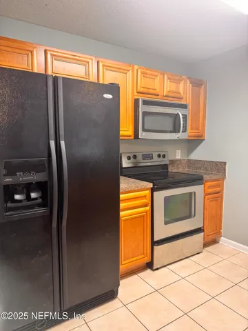 a kitchen with granite countertop a refrigerator and a stove