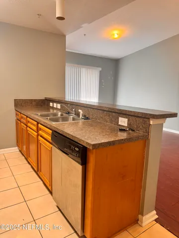 a view of a kitchen with stainless steel appliances granite countertop a sink and cabinets