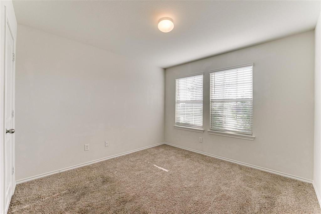 517 Milo Way Royse City, TX 75189 - Photo 18 of 34 Carpeted interior room featuring two windows with blinds, a ceiling-mounted light fixture, white walls, and white baseboards