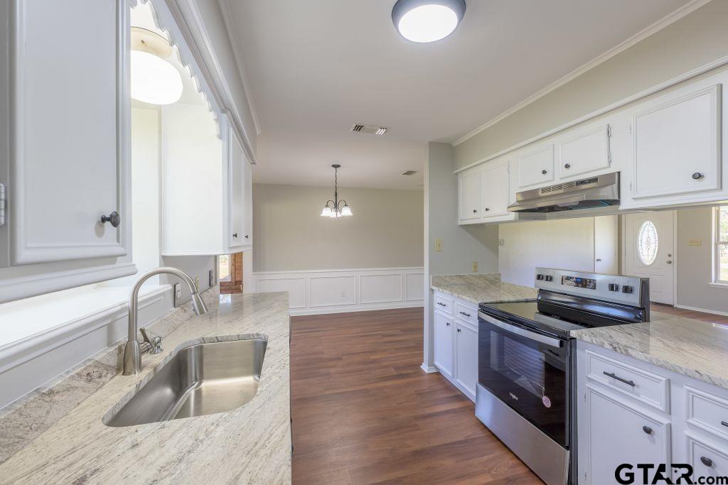a kitchen with granite countertop a sink and a stove