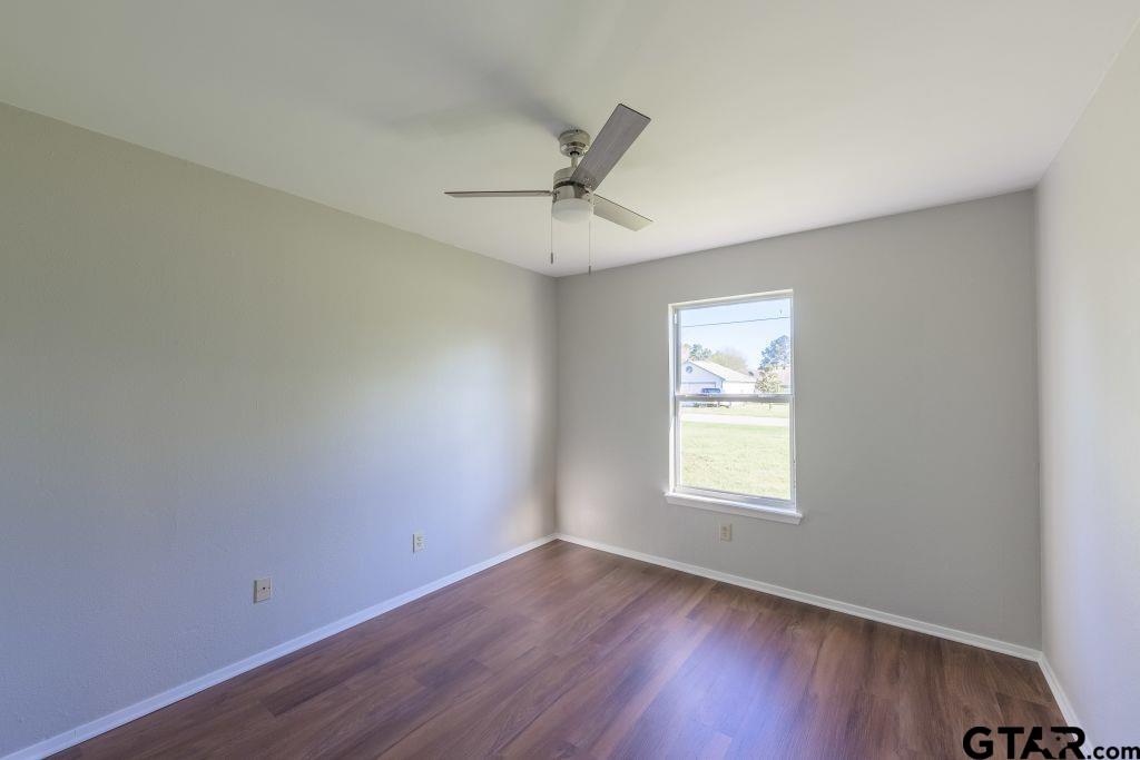 14212 Arber Street Flint, TX 75762 - Photo 27 of 38 an empty room with wooden floor ceiling fan and windows