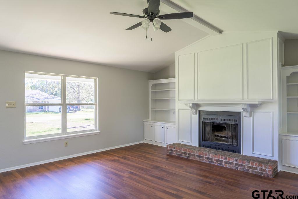 14212 Arber Street Flint, TX 75762 - Photo 10 of 38 a view of an empty room with wooden floor fireplace and a window