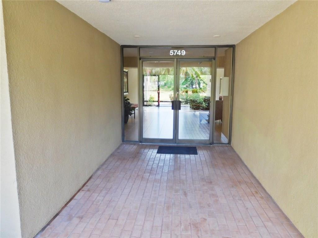 5749 Camino Del Sol, Unit 202 Boca Raton, FL 33433 - Photo 3 of 35 a view of an empty room with wooden floor and a window