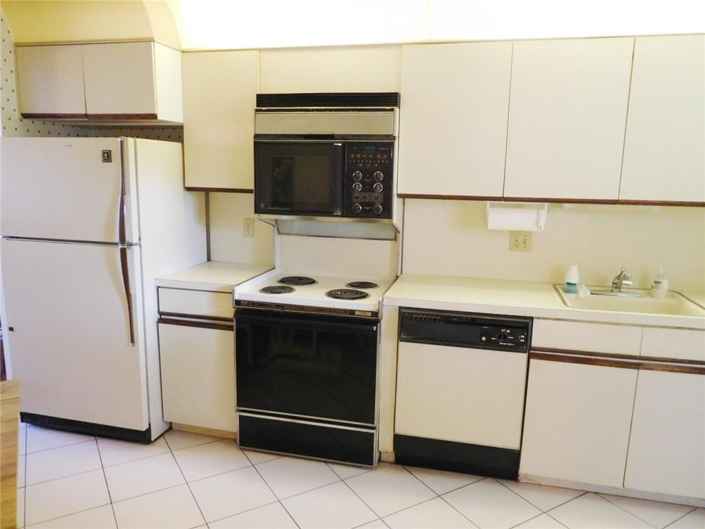 5749 Camino Del Sol, Unit 202 Boca Raton, FL 33433 - Photo 10 of 35 a kitchen with a stove refrigerator and microwave