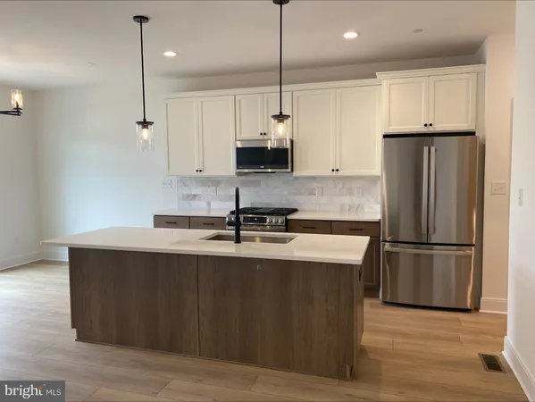 a kitchen with kitchen island a sink stainless steel appliances and refrigerator