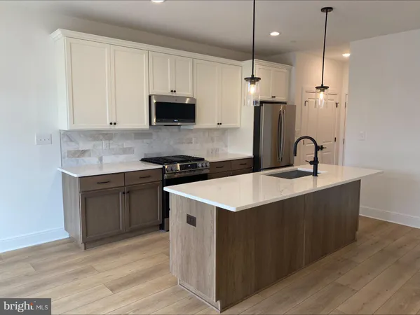 a kitchen with granite countertop a sink a stove and refrigerator
