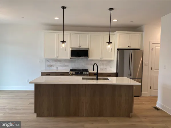 a kitchen with stainless steel appliances granite countertop a sink a refrigerator and a granite counter tops