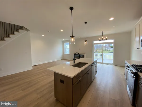 a kitchen with a stove and a wooden floor
