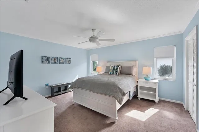 a bedroom with a bed and a flat tv screen on dresser