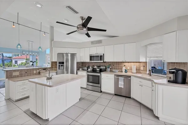 a kitchen with white cabinets stainless steel appliances and sink
