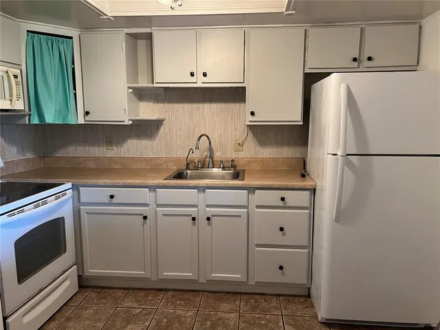 a white refrigerator freezer sitting inside of a kitchen