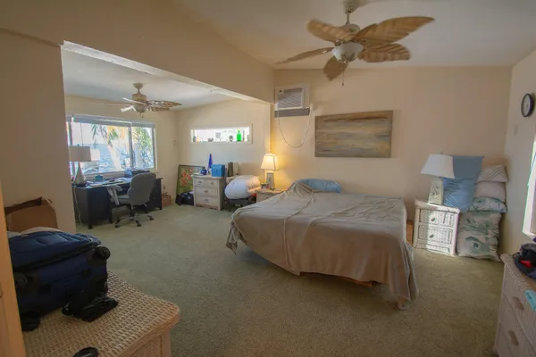 a bedroom with a bed chair and window