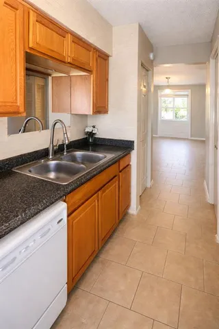 a kitchen with granite countertop a sink and cabinets