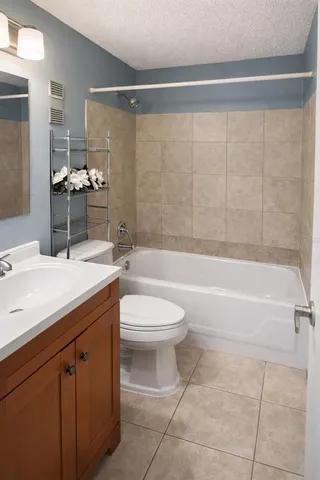 a bathroom with a granite countertop sink a toilet and shower