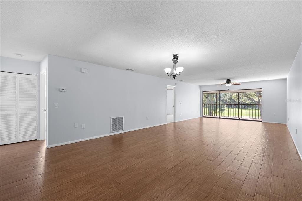 6110 Country Club Way, Unit 204 Sarasota, FL 34243 - Photo 14 of 66 a view of an empty room with wooden floor and a window
