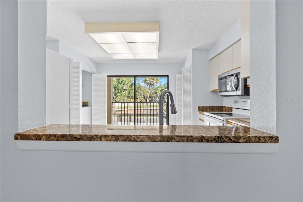 6110 Country Club Way, Unit 204 Sarasota, FL 34243 - Photo 32 of 66 a living room with kitchen island granite countertop furniture and a large window