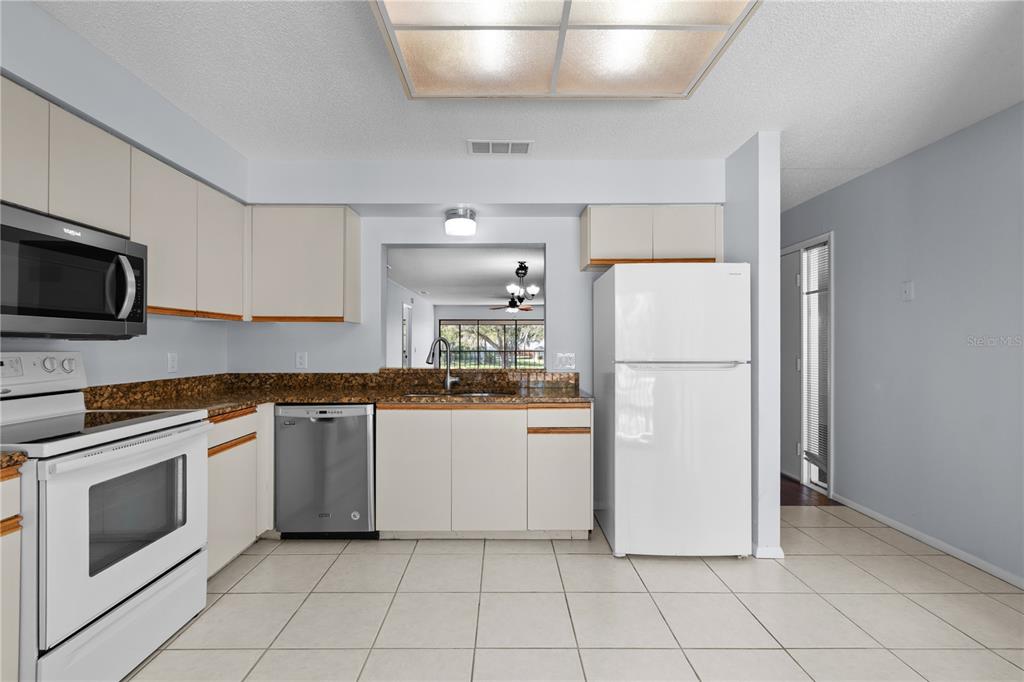 6110 Country Club Way, Unit 204 Sarasota, FL 34243 - Photo 35 of 66 a kitchen with white cabinets and white appliances