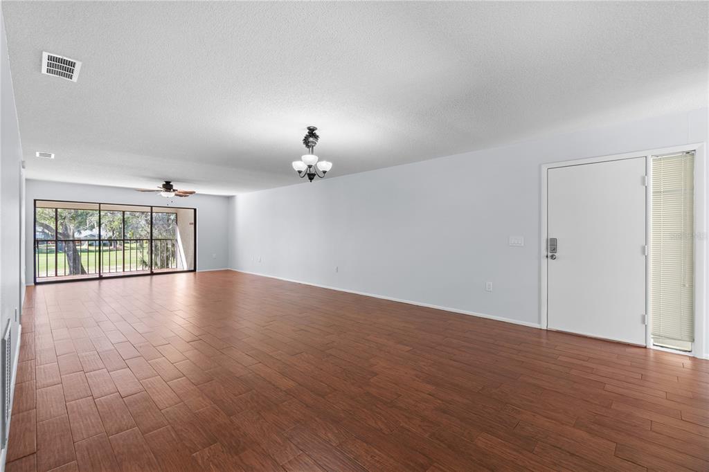 6110 Country Club Way, Unit 204 Sarasota, FL 34243 - Photo 9 of 66 a view of an empty room with wooden floor and a window