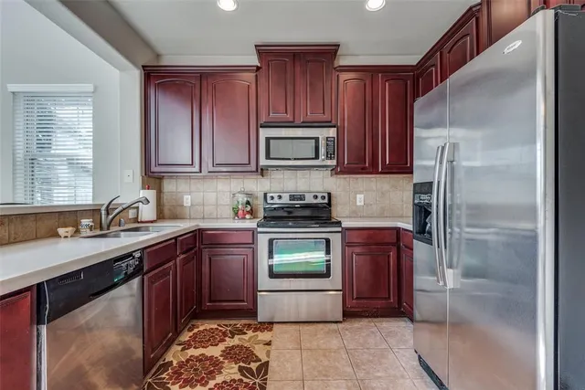 a kitchen with stainless steel appliances granite countertop a stove a refrigerator and a sink