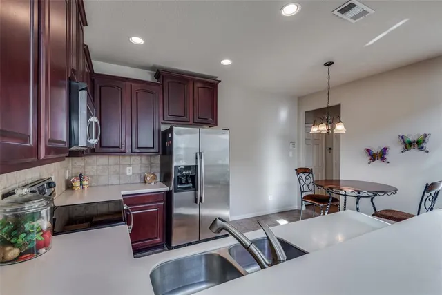 a kitchen with refrigerator a stove and a wooden cabinets