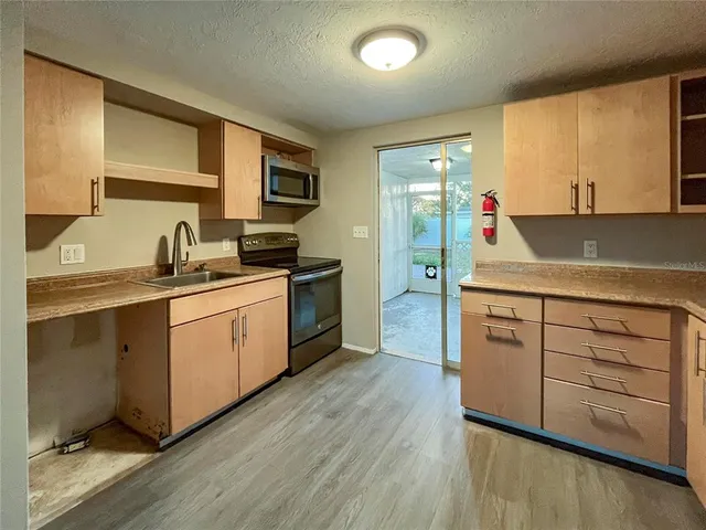 a kitchen with white cabinets and sink