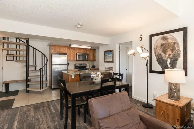 a view of a dining room with furniture a rug and wooden floor