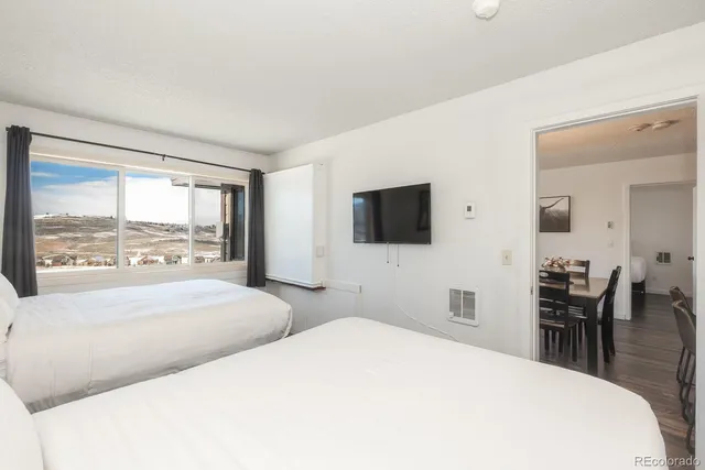 a bedroom with a bed and a flat tv screen on dresser