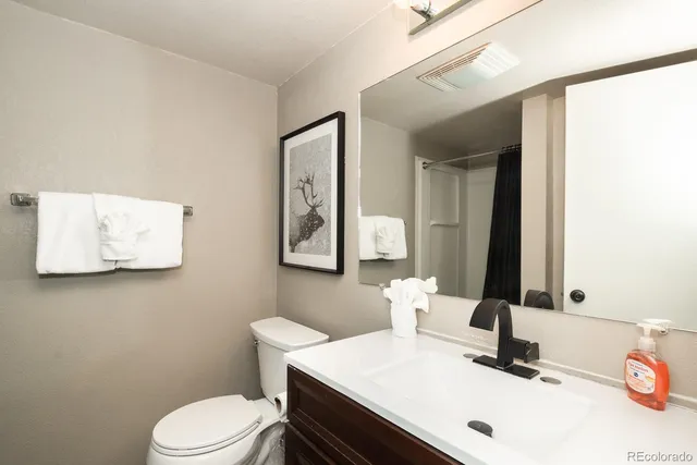 a kitchen with granite countertop a refrigerator and a stove top oven