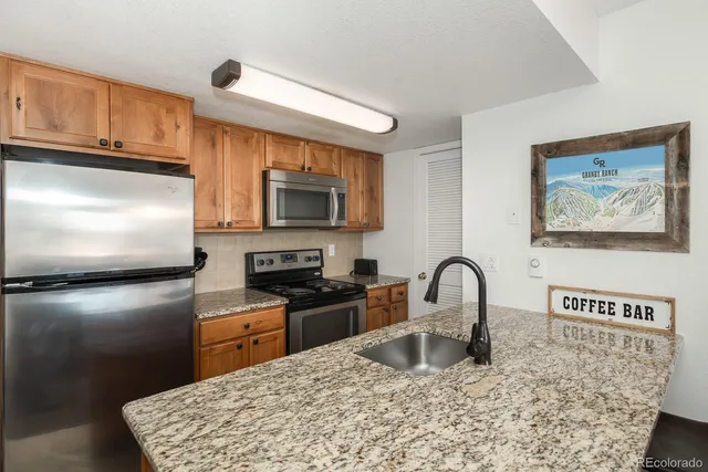 a kitchen with stainless steel appliances kitchen island granite countertop a kitchen island hardwood floor sink and stove