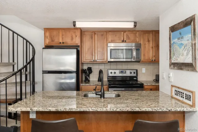 a kitchen with stainless steel appliances granite countertop a sink stove and microwave