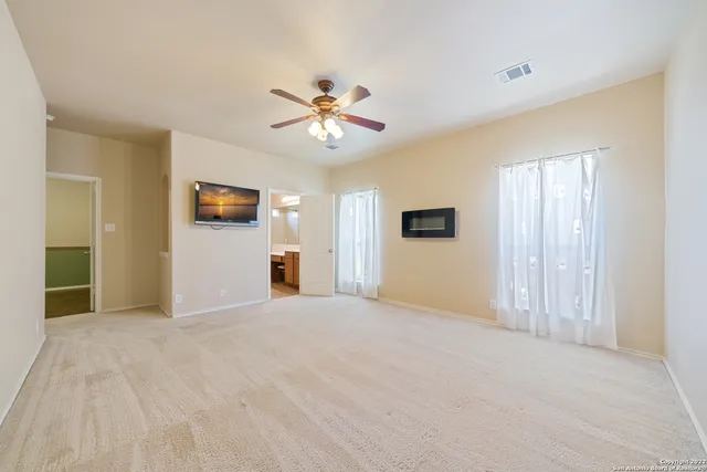 a view of empty room with window and ceiling fan