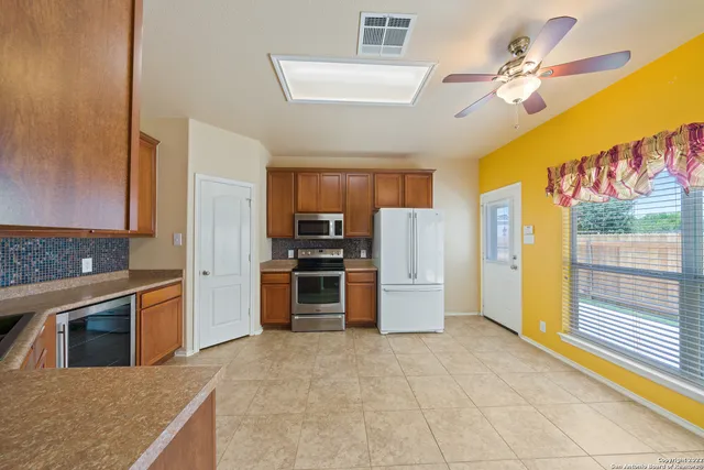 a kitchen with stainless steel appliances granite countertop a refrigerator and a stove